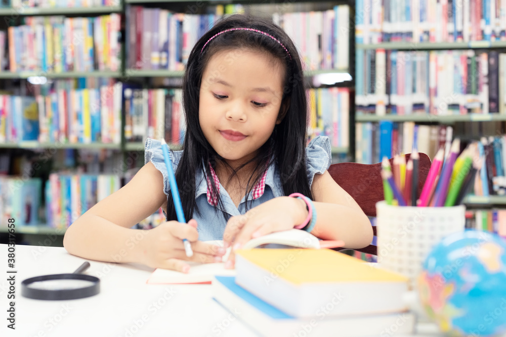 Asian girl and children writing and reading books for education and go to school in library. Education and Lifestyle Concept Asian girl and children writing and reading books for education and go to school in library. Education and Lifestyle Concept