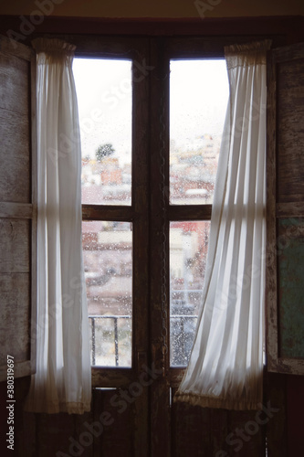View through rustic window with curtains in old building