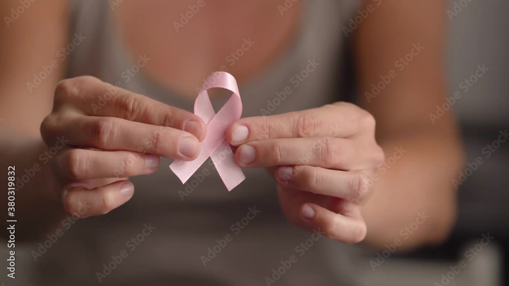Woman hold pink ribbon. Close up view of hand with symbol of national breast canser awareness month in october. Woman hold pink ribbon. Close up view of hand with symbol of national breast canser awareness month in october.