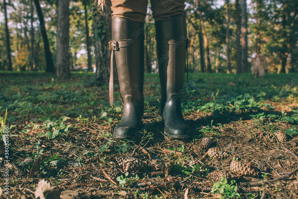 Woman wearing black boots and standing on leaves Woman wearing black boots and standing on leaves