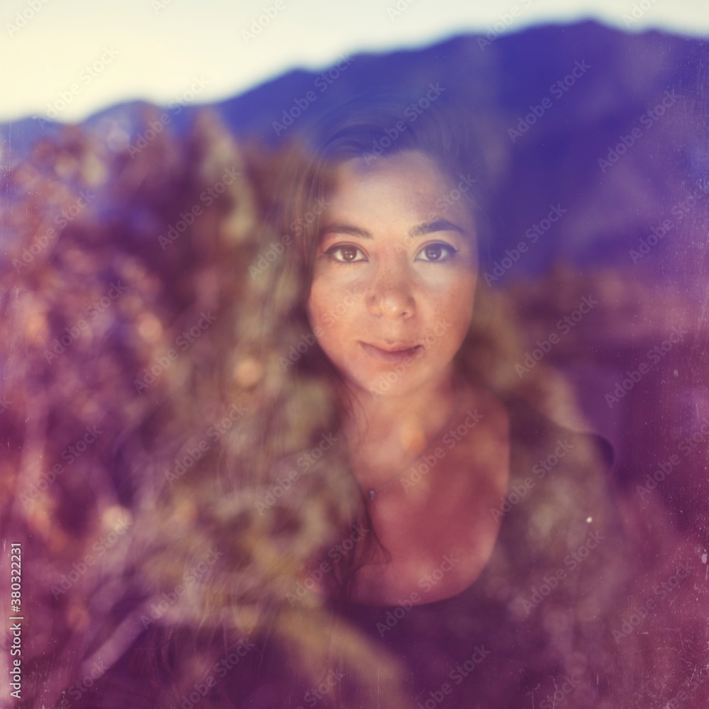 A pretty girl stares through a window reflecting the mountains A pretty girl stares through a window reflecting the mountains