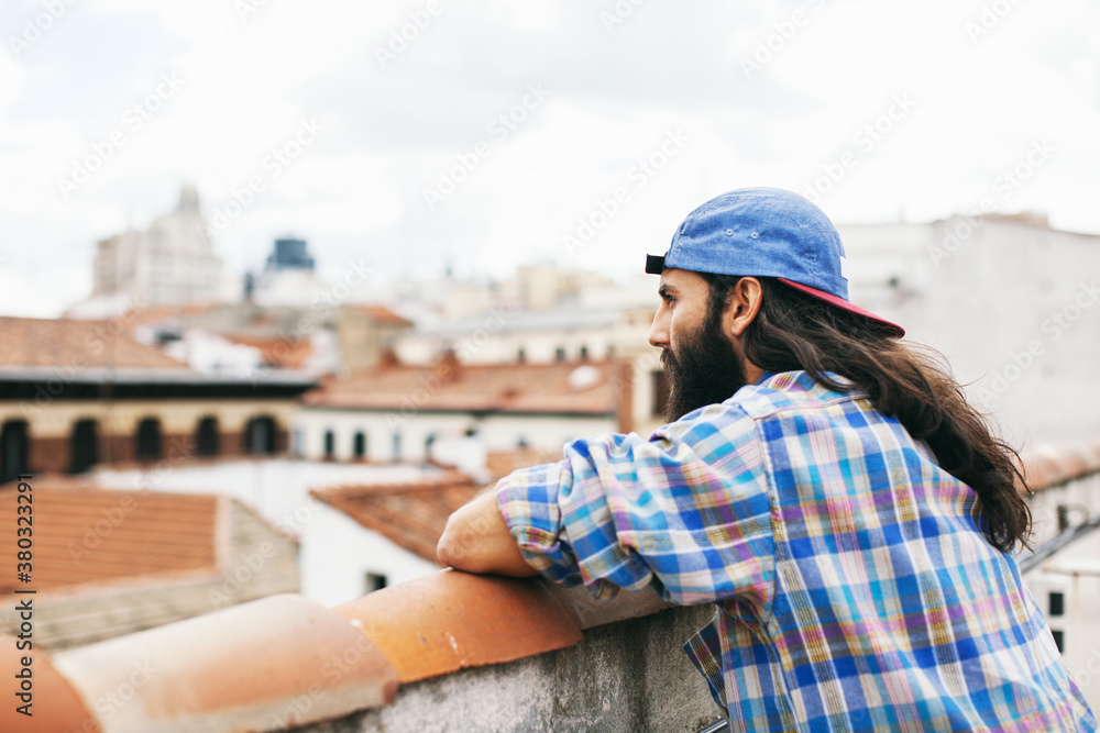 Young hipster man looking beautiful views from the terrace. Young hipster man looking beautiful views from the terrace.