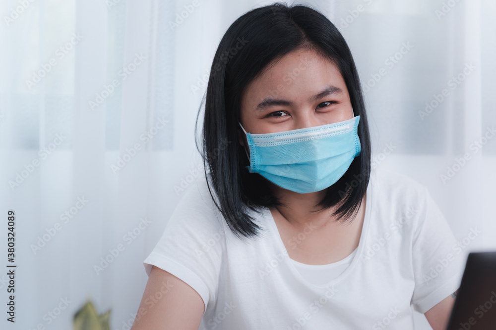 Young business woman wearing mask working from home  while quarantine from coronavirus  outbreak