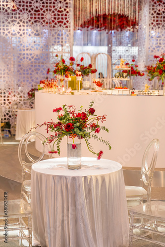 luxury wedding decor with flowers and glass vases and number of setting on round tables