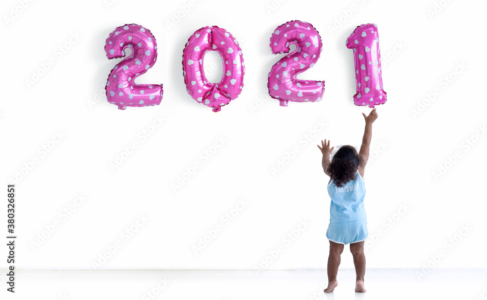 Dark skinned little girl with afro hair is arranging pink balloons for new year 2021, new year 2021, Pink party balloons 2021 numbers shape Dark skinned little girl with afro hair is arranging pink balloons for new year 2021, new year 2021, Pink party balloons 2021 numbers shape