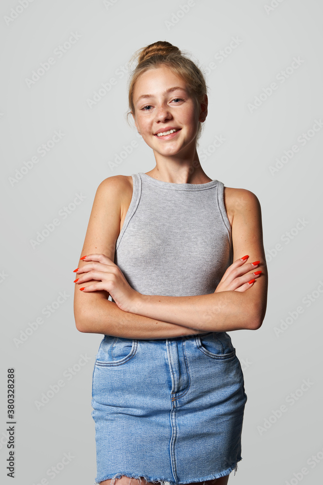 Teen girl in denim skirt looking at camera smiling Teen girl in denim skirt looking at camera smiling