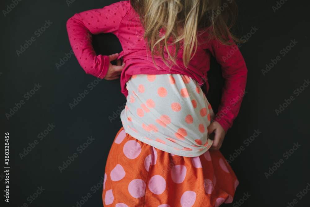 A girl with layers of polka dots examines her outfit A girl with layers of polka dots examines her outfit