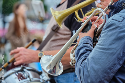 The person holds a music pipe and plays outside.