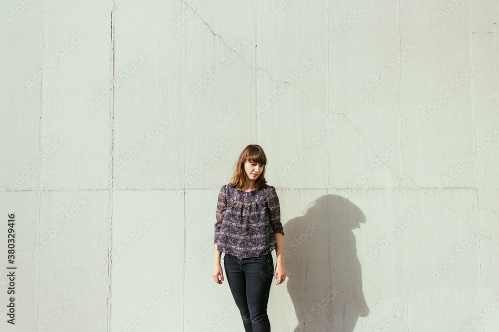 Young woman waiting by white wall Young woman waiting by white wall