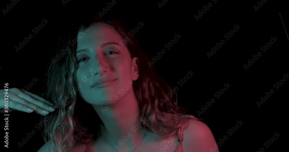 Beautiful young woman is dancing in party. Neon, blue and red light in studio shot, club and music with girl concept. Multicolored skin, ultraviolet light. Beautiful young woman is dancing in party. Neon, blue and red light in studio shot, club and music with girl concept. Multicolored skin, ultraviolet light.