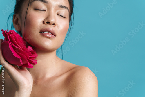 Image of pleased shirtless asian girl posing with rose