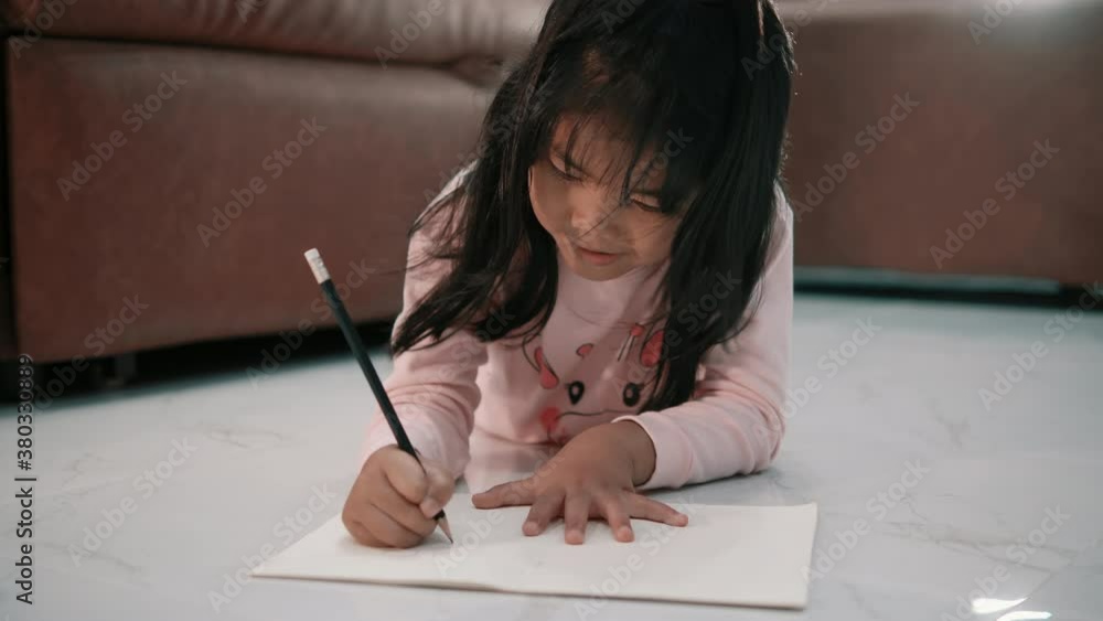 Cute child girl writing or learning and smiling, adorable pretty little preschool kid studying alone making note or drawing, children education concept Cute child girl writing or learning and smiling, adorable pretty little preschool kid studying alone making note or drawing, children education concept
