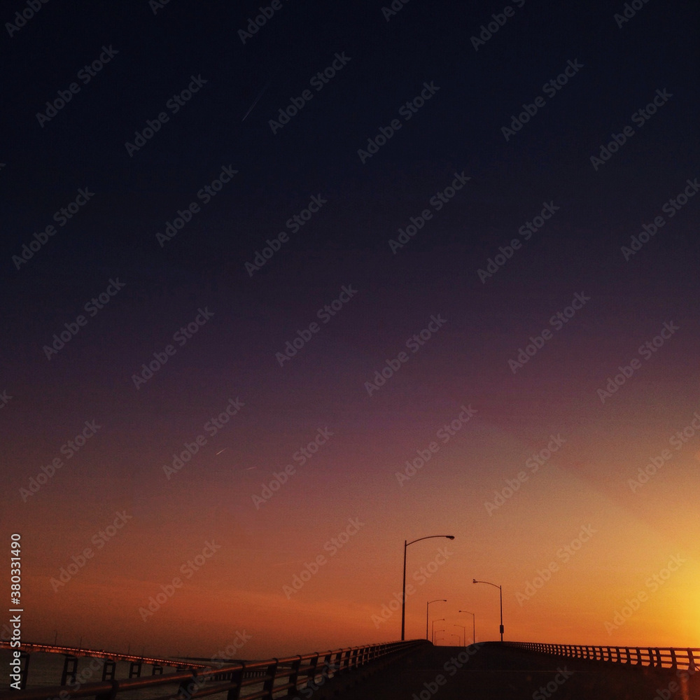 The Sun setting over an empty bridge