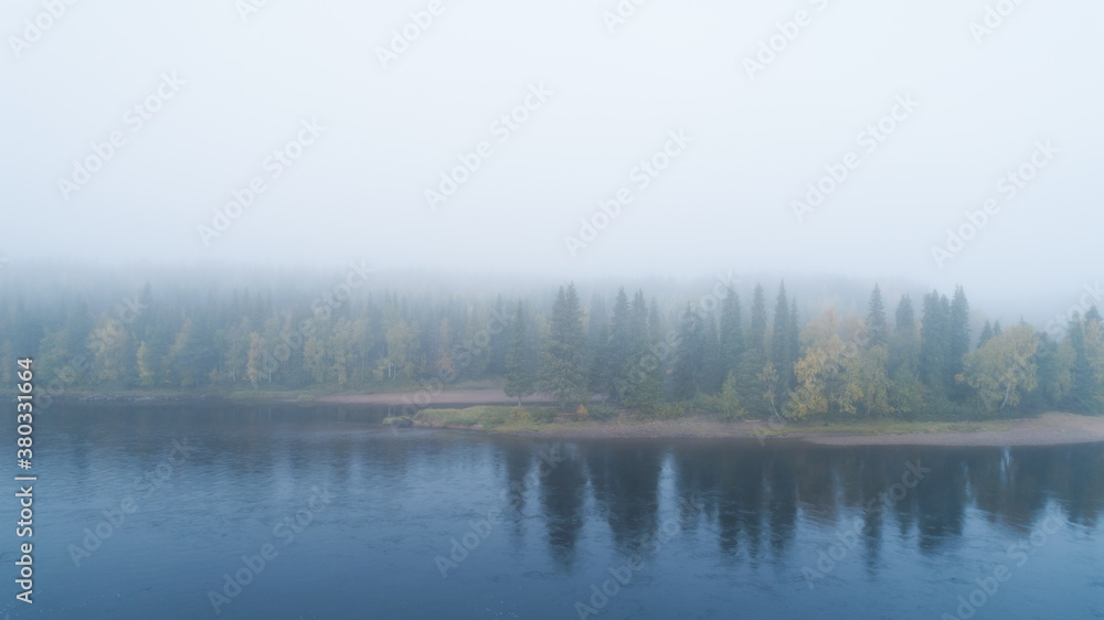 Autumn with mirrored forest and misty Northern river. Morning on the river. Lapland. Autumn with mirrored forest and misty Northern river. Morning on the river. Lapland.