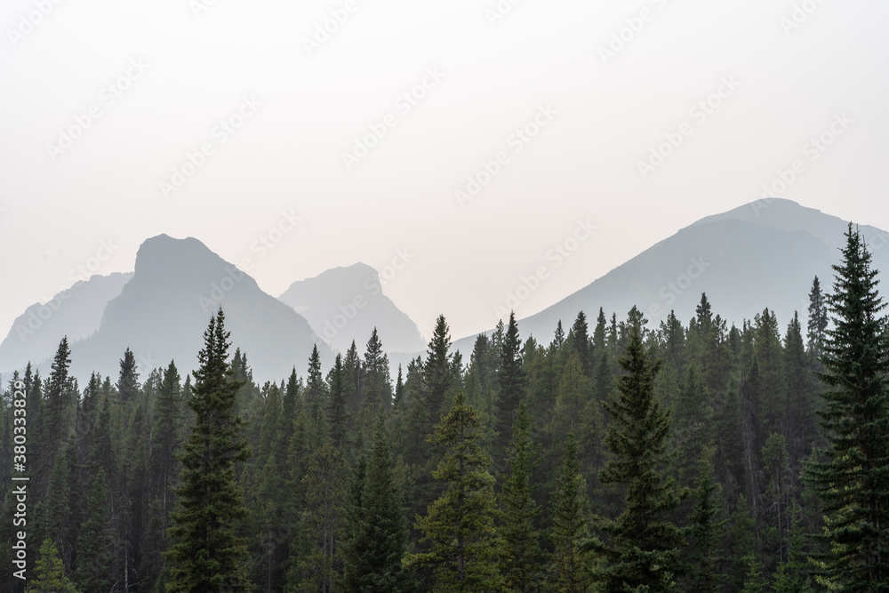 Beautiful silhouette of the mountains in Banff national park against the morning fog.
