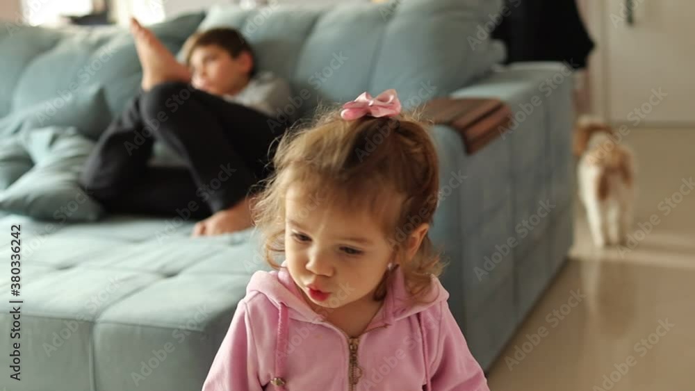Criança brincando dentro de casa. Pai filmando a filha em camera lenta. Criança brincando dentro de casa. Pai filmando a filha em camera lenta.