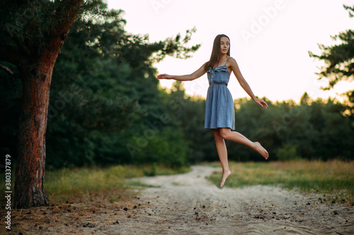 Woman levitates in forest above the ground.