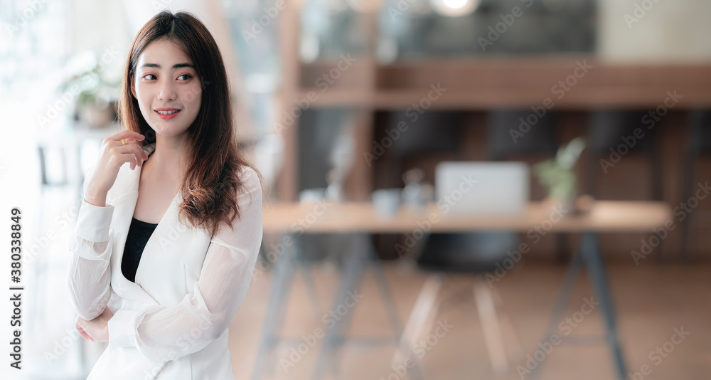 Portrait of young pretty asian businesswoman standing in office, copy space, panoramic view. Portrait of young pretty asian businesswoman standing in office, copy space, panoramic view.