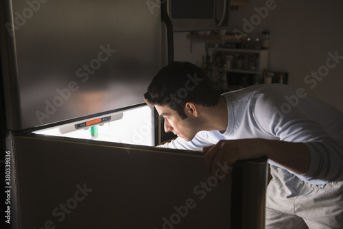 Man opening fridge at night