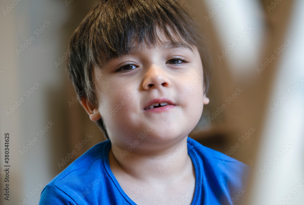 New normal life. Candid shot kid looking at camera with smiling face, Selective focus Happy Child sitting alone playing alone with blurry foreground, Little boy relaxing at home. New normal life. Candid shot kid looking at camera with smiling face, Selective focus Happy Child sitting alone playing alone with blurry foreground, Little boy relaxing at home.