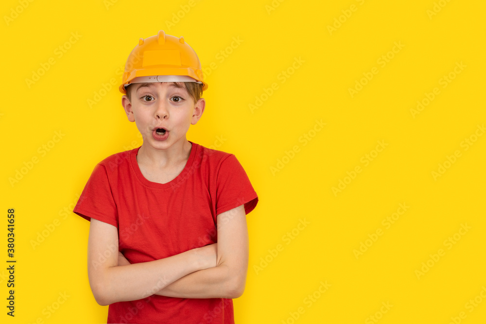 Surprised guy in orange construction helmet on yellow background. Choice of specialty. Copy space Surprised guy in orange construction helmet on yellow background. Choice of specialty. Copy space