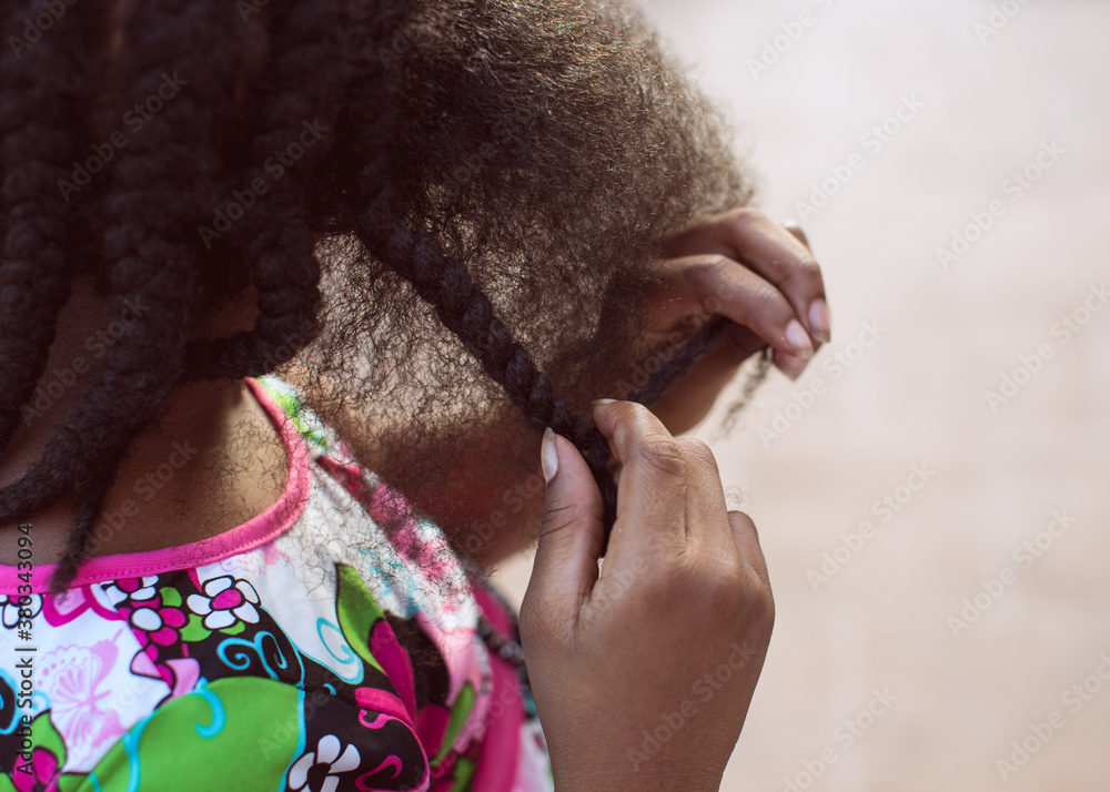 Young black girl getting her hair braided Young black girl getting her hair braided