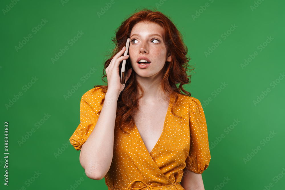 Image of ginger serious girl talking on mobile phone Image of ginger serious girl talking on mobile phone