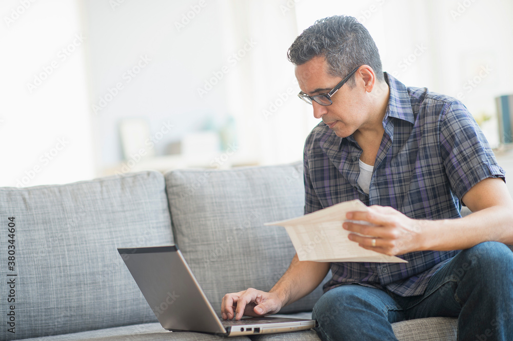 Man doing home finances with laptop Man doing home finances with laptop