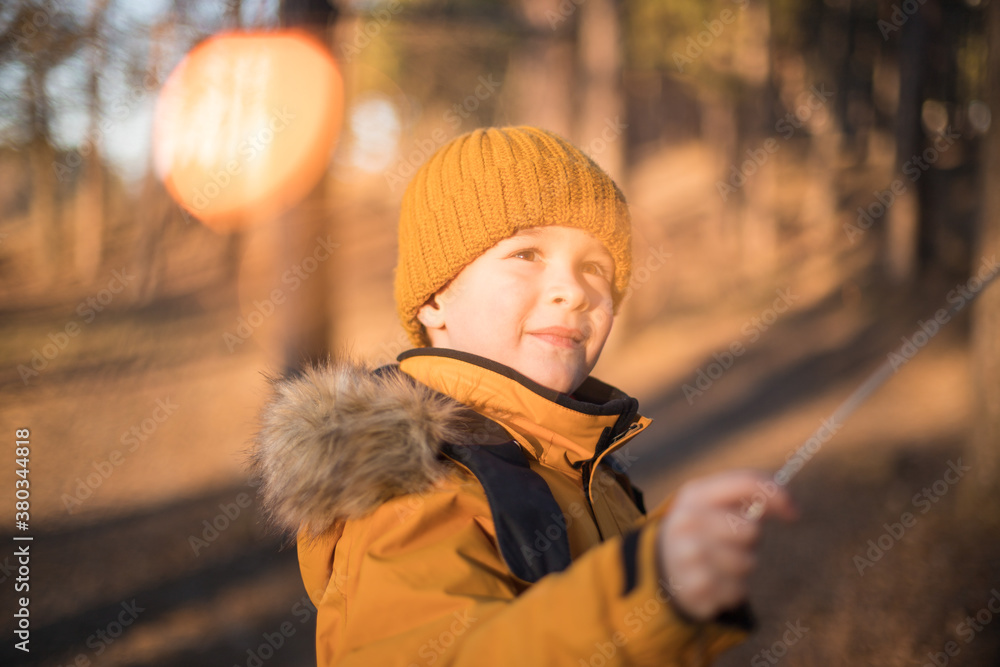 Cute toddler boy walks in a hat in the forest on a warm winter day. Portrait of a child on the street Cute toddler boy walks in a hat in the forest on a warm winter day. Portrait of a child on the street