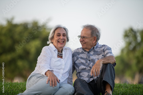 an elderly couple sitting outdoors