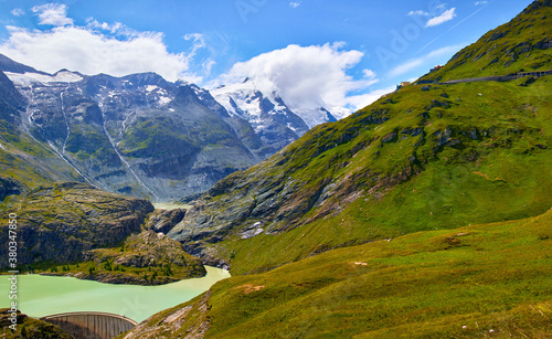 Panoramic view at Pasterze Glacier Grossglockner among austrian Alps mountains summits blue sky clouds.