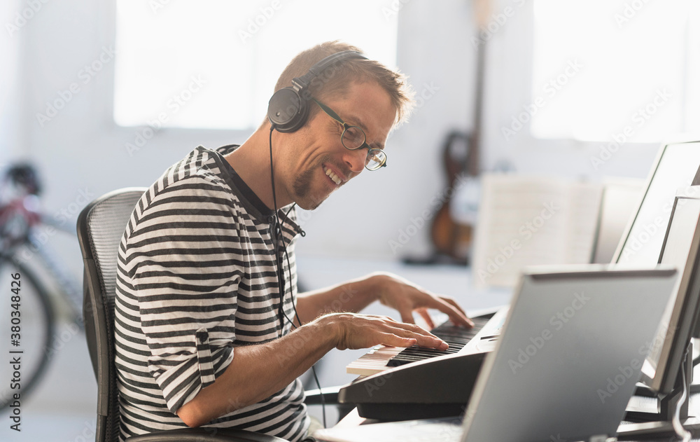 Man using laptop and synth to make music Man using laptop and synth to make music