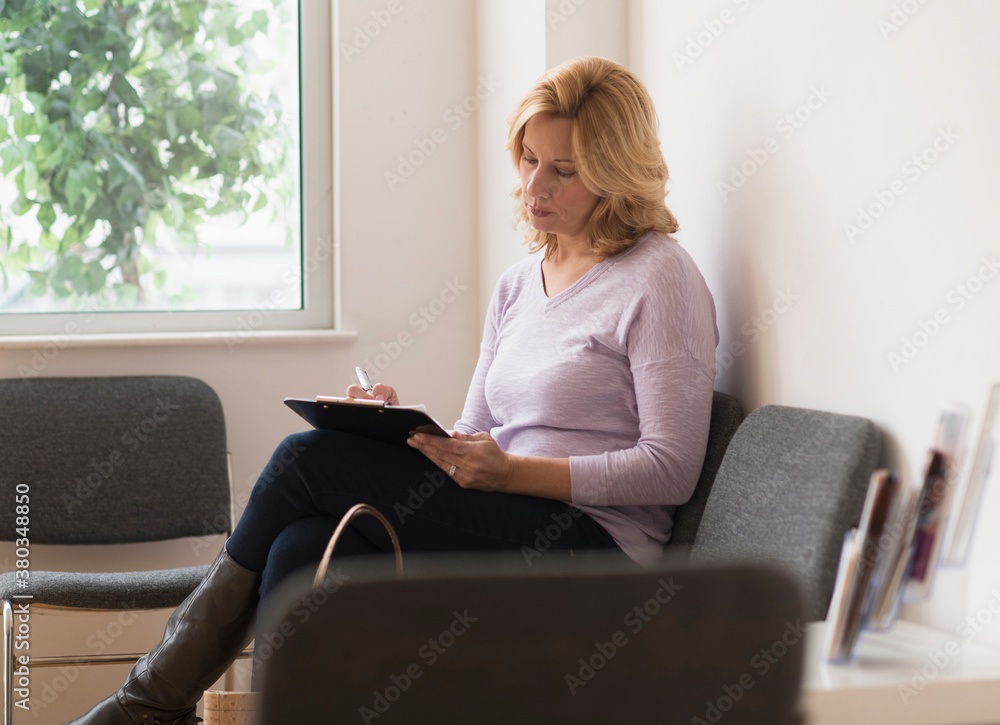 Woman sitting in waiting room Woman sitting in waiting room