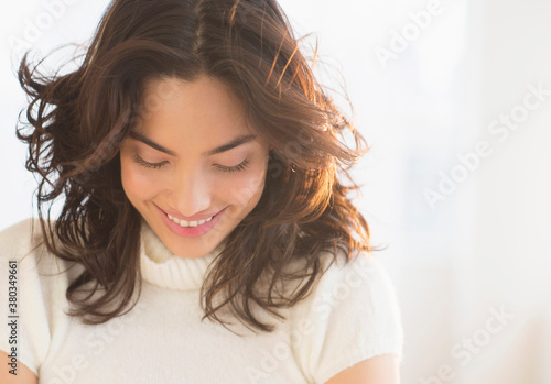 Smiling young brunette woman looking down