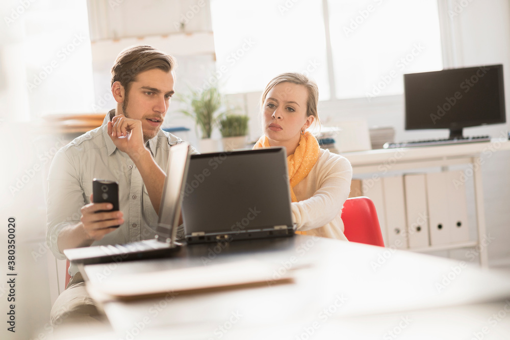 Young man and woman working together with laptop in office Young man and woman working together with laptop in office