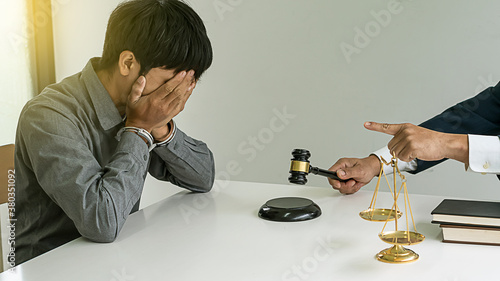 A locked man, handcuffed, and a lawyer holding a hammer and scales of justice.