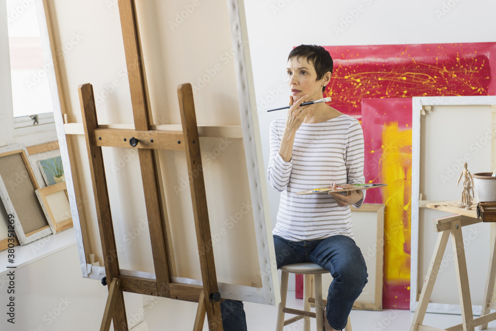 Female artist painting in her studio Female artist painting in her studio