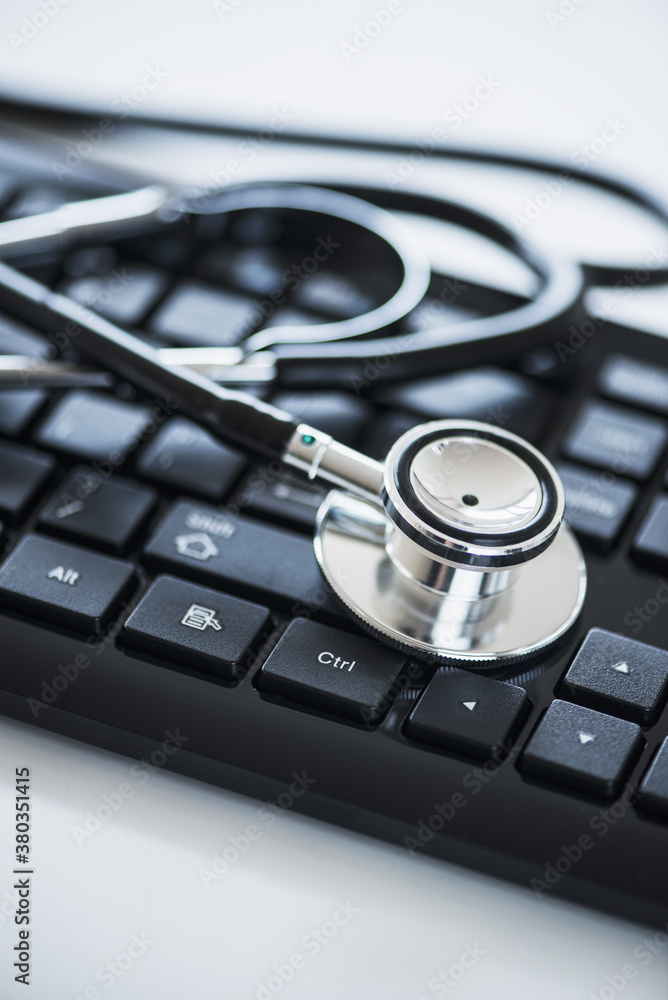 Close up of computer keyboard and stethoscope, studio shot Close up of computer keyboard and stethoscope, studio shot