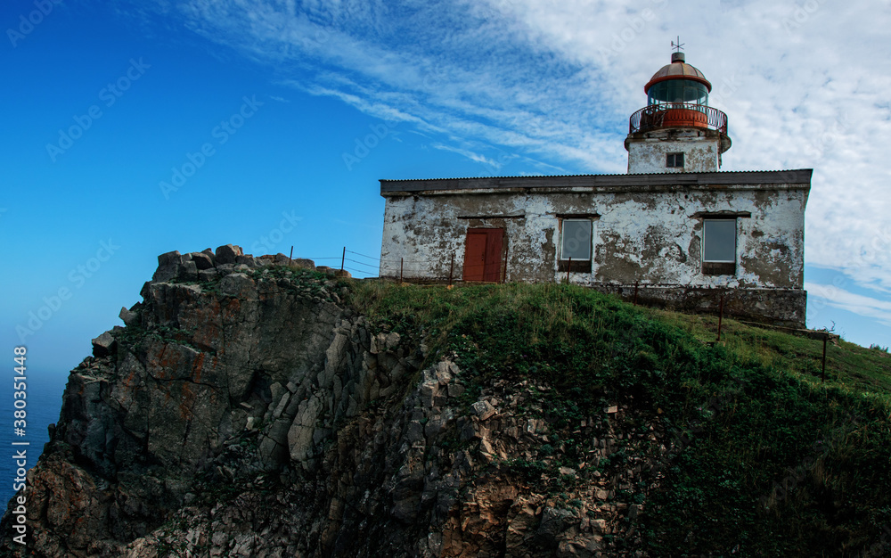 Fototapeta premium Old lighthouse located on the Pacific ocean. Beautiful scenery on a Sunny day.