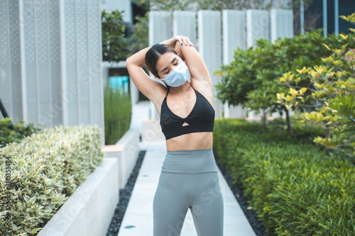 Woman with mask meditating in nature alone.Social distancing and active healthy lifestyle. Mindfulness meditation practice