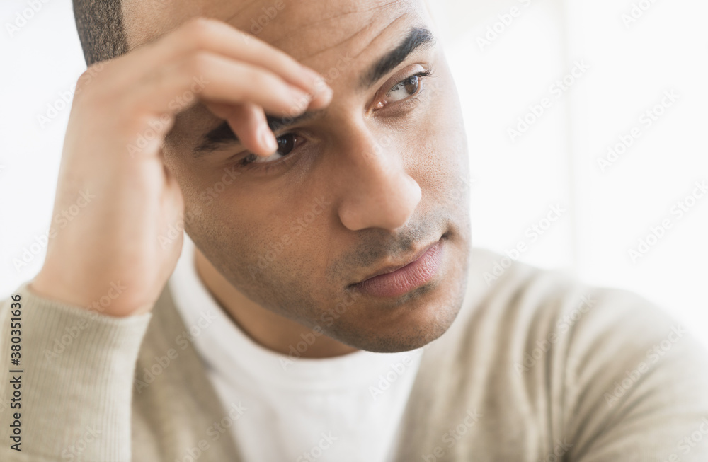 Portrait of young man holding head in hands Portrait of young man holding head in hands