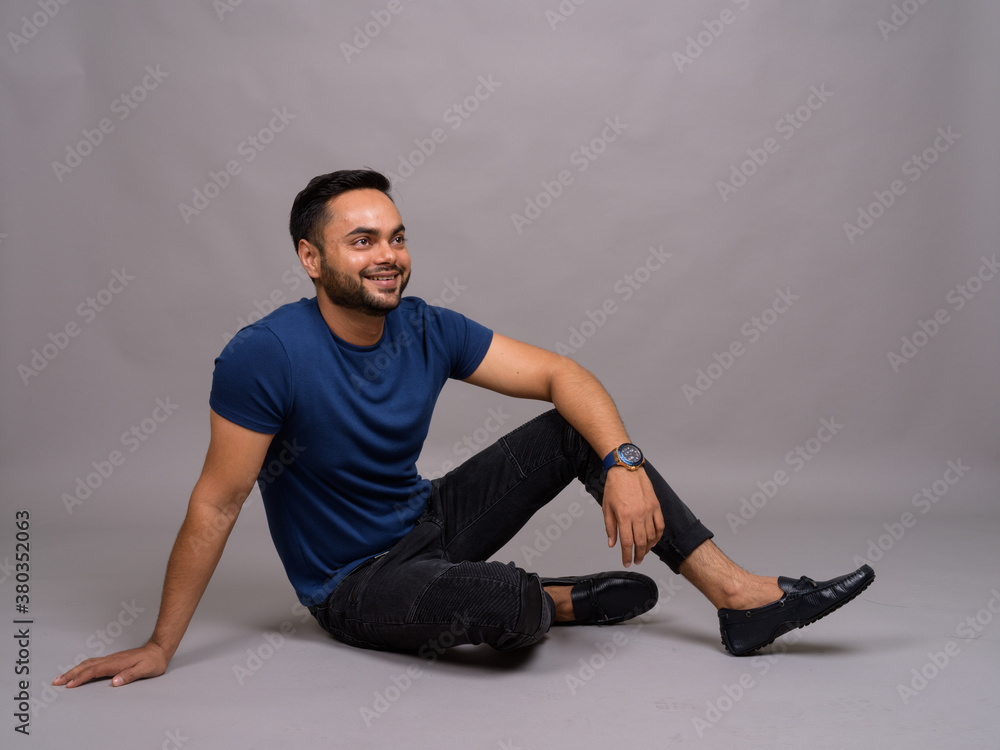 Young bearded Indian man against gray background Young bearded Indian man against gray background
