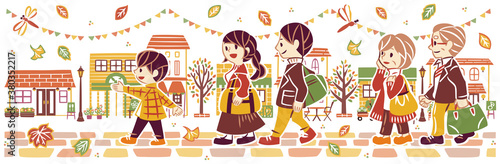 秋の紅葉の街並みを旅行する三世代家族