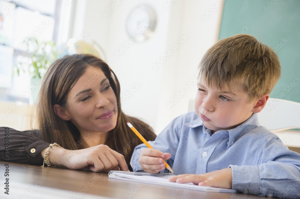 Female teacher and schoolboy (6-7) in classroom Female teacher and schoolboy (6-7) in classroom