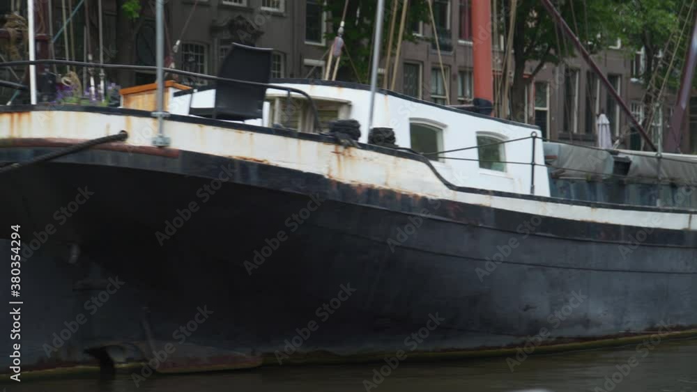 some old rusty boats parked in an Amsterdam's canal some old rusty boats parked in an Amsterdam's canal