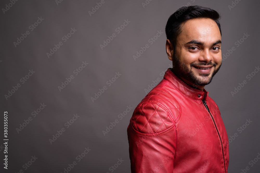 Obraz premium Young bearded Indian man against gray background