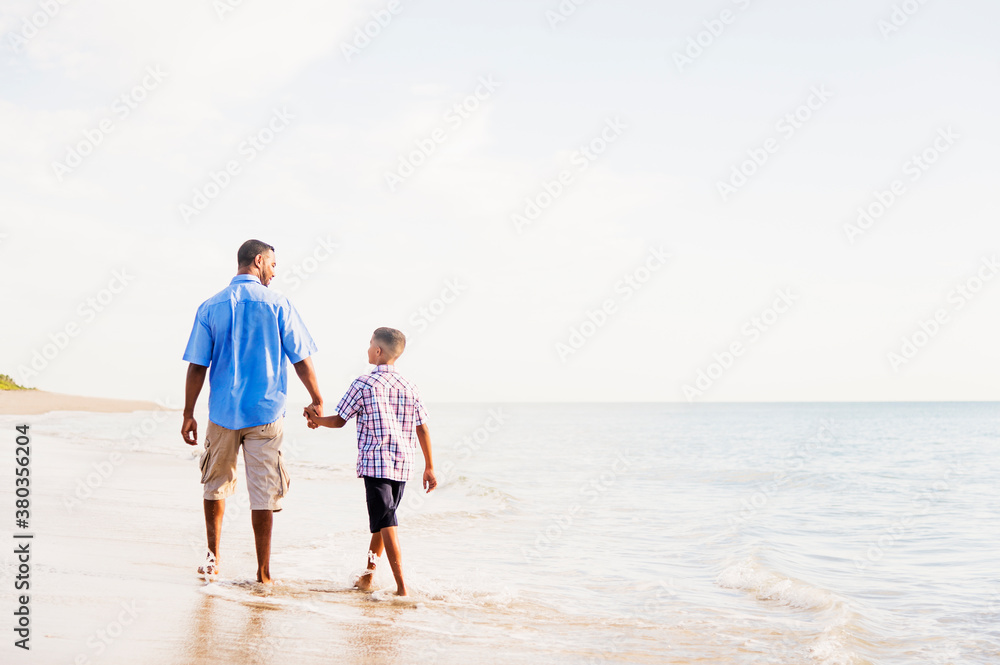 Father and son (10-11) walking on beach Father and son (10-11) walking on beach