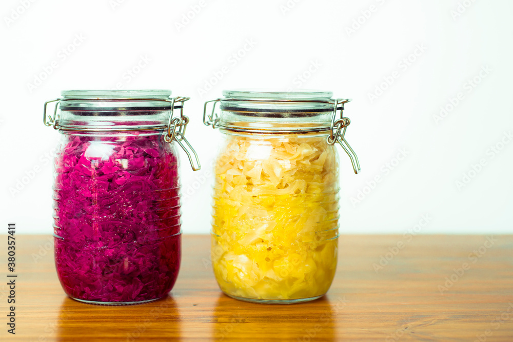 Jar of tasty sauerkraut on wooden table with peppermint and bay leaf, wooden spoon Jar of tasty sauerkraut on wooden table with peppermint and bay leaf, wooden spoon