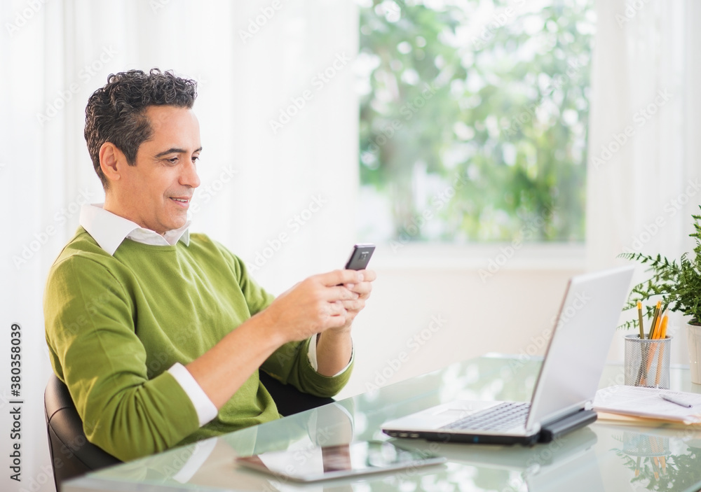 Portrait of man using mobile phone at desk Portrait of man using mobile phone at desk
