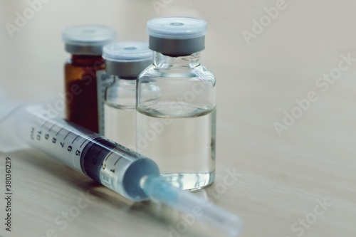 Vaccine vials and syringe on table.